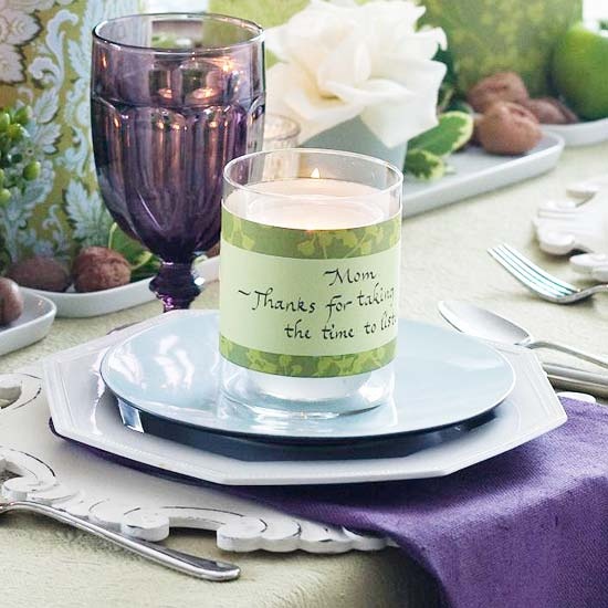 a catchy Thanksgiving tablescape with purple glasses and napkins, greenery, green apples and green touches here and there