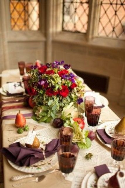 a bold Thanksgiving tablescape with neutral linens, purple napkins and glasses, bold blooms and greenery, pears and succulents is gorgeous
