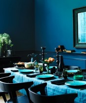 a moody Thanksgiving tablescape in the shades of blue and with black touches and spruced up with shiny gold details