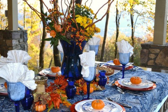 a blue printed tablecloth, bold blue glasses, candleholders and a vase make the tablescape chic, unusual and very bright