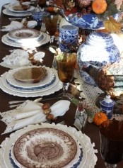 a traditional Thanksgiving tablescape done in brown, white, orange and spruced up with blue accents