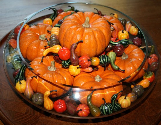 a fall or Thanksgiving centerpiece of a large glass bowl with lots of faux pumpkins and gourds of various sizes is a very cool idea