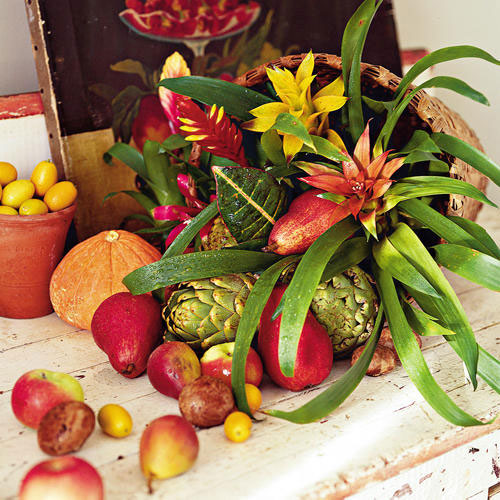 a basket with greenery, blooms and fresh veggies and fruits is a lovely centerpiece or decoration for Thanksgiving