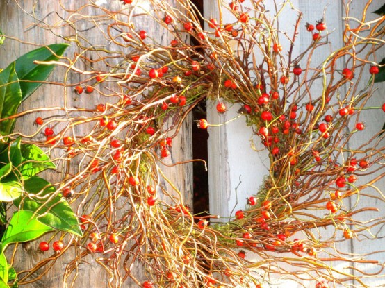 a lovely all-natural wreath of branches, greenery and berries and moss is a chic fall or Thanksgiving decoration