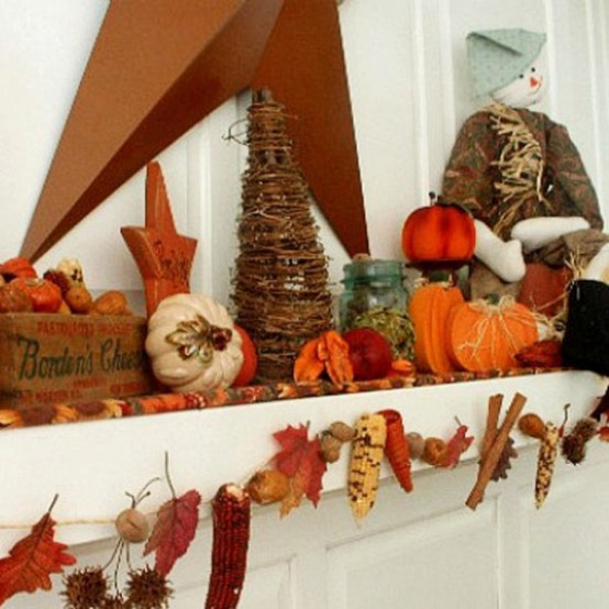 a rustic Thanksgiving mantel with real leaves, nuts, acorns, corn cobs, faux pumpkins stacked, wooden stars and wooden pumpkins is lovely and cozy