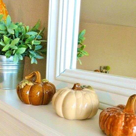 simple fall or Thanksgiving mantel with porcelain pumpkins and greenery in a bucket can be decorated last minute and looks cute
