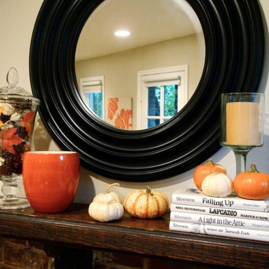 faux mini pumpkins, candles and pinecones and leaves in a glass jar for pretty Thanksgiving decor