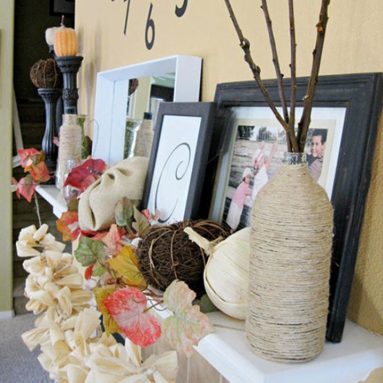 a vintage Thanksgiving mantel with bold faux leaves, a burlap garland, faux pumpkins of various materials and branches in a twine wrapped vase