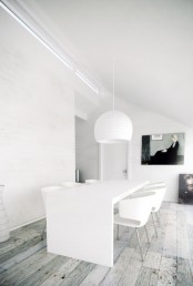 a white minimalist dining space with a large table and chairs, a white pendant lamp is a cool and all-minimal space, free of clutter