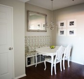 a vintage-inspired dining area with a printed bench with storage, a white table and chairs that match the bench, a chic chandelier