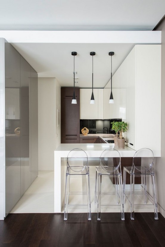 a minimalist dining space with a high countertop, ghost stools and a trio of pendant lamps plus potted greenery