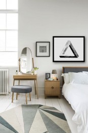 a neutral modern bedroom with light-stained furniture, white bedding, a pretty geometric rug that makes a statement, graphic artwork and a mirror