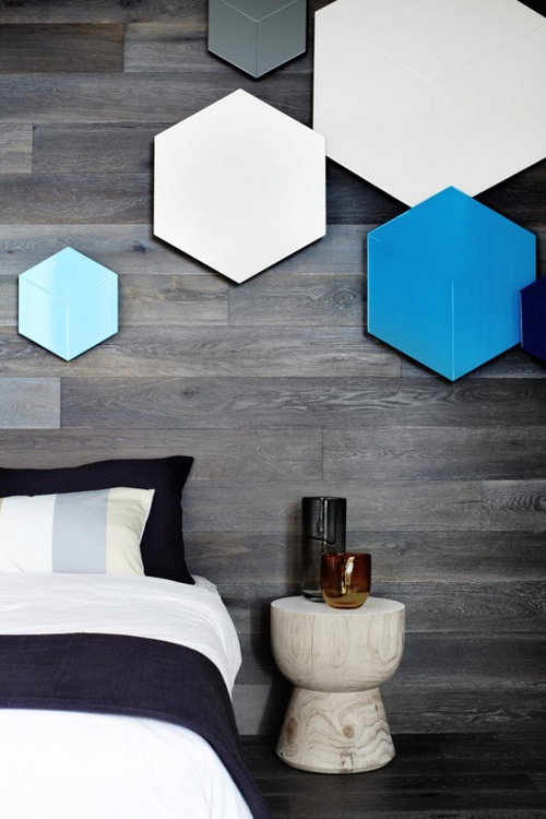 a bedroom with a wooden accent wall decorated with colorful hexagons for a bold and pretty look