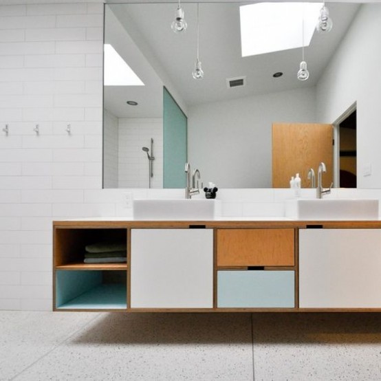 a creative mid-century modern bathroom in neutrals, with a color block vanity and pendant lamps