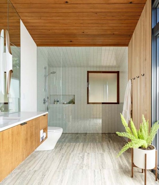 neutral wooden floors, white skinny tiles and wooden paneling on the walls and ceiling, a floating wooden vanity and a potted plant to compose a mid-century modern bathroom