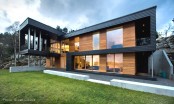 Twofold House In Black Stained Wood With Natural Wood Between The Window Partitions