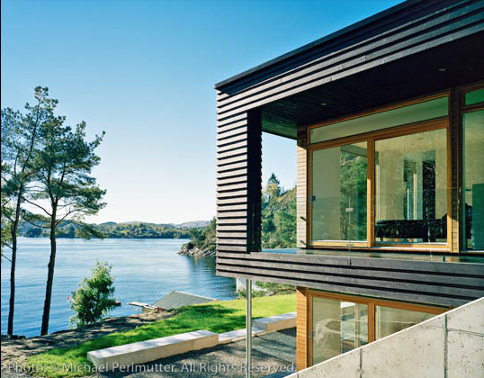 Twofold House In Black Stained Wood With Natural Wood Between The Window Partitions