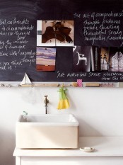 a chalkboard accent wall with photos and some writing turn this little sink space into a small and cozy nook with memories