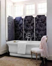a beautiful bathroom with neutral walls, a bathtub placed next to the bow window, which is covered with chalkboard panels, is a chic space