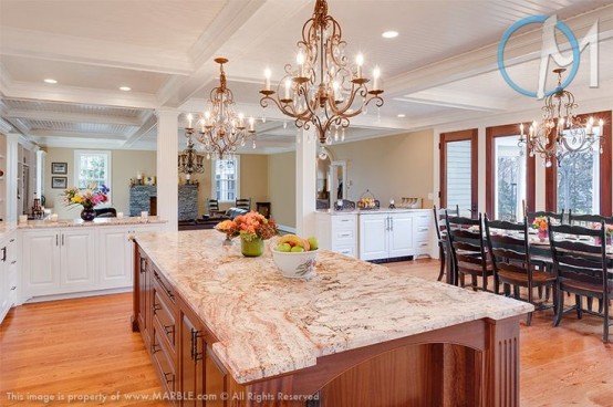white cabinets with light-colored stone countertops and a rich stained kitchen island with a grey stone countertop