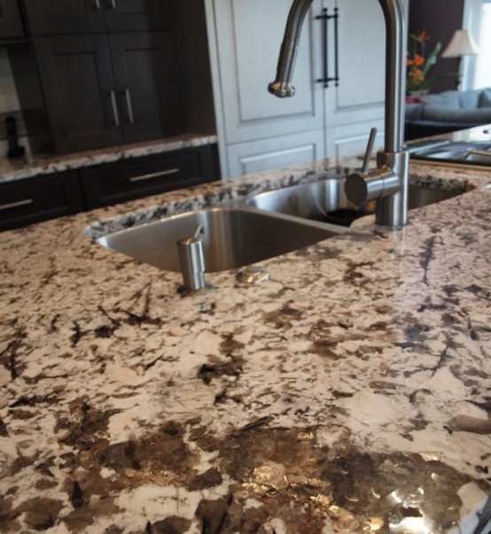 a dark stone countertop with light-colored and dark wooden cabinets make up a bold and creative kitchen look