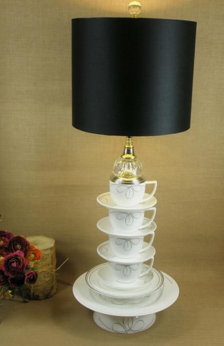 a black table lamp with a base made of teaware and a sleek black lampshade is a cool idea with a quirky feel, reminds of Alice in Wonderland