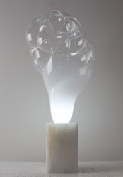 a unique bubble-inspired table lamp with a white stone base and an unusual bubble-like top