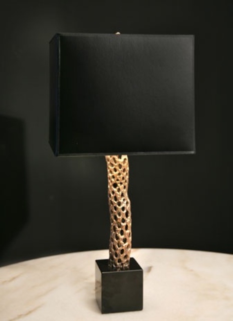 a refined black and gold table lamp with a sleek lampshade and a gold textural base to add a sophisticated touch to the space