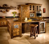 a large dark stained wood kitchen island with drawers and drink coolers matches the kitchen and looks very cozy