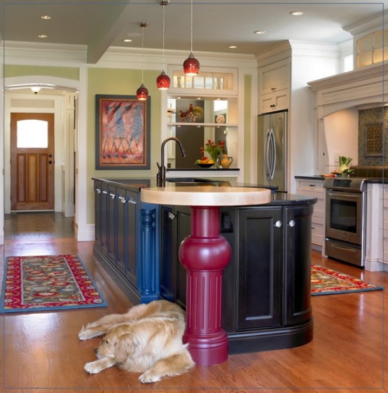 a large kitchen island in black and blue, with a round table with a stone tabletop and a pink leg looks really unusual