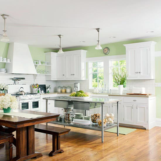 a simple metal kitchen island with an open shelf contrasts the traditional white kitchen and a dark stained wooden dining set