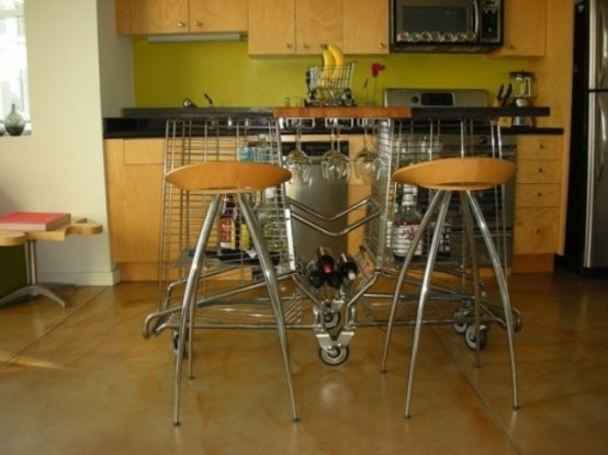 a strange looking kitchen island of metal on casters and with a wooden tabletop contrasts the simple and modern plywood kitchen