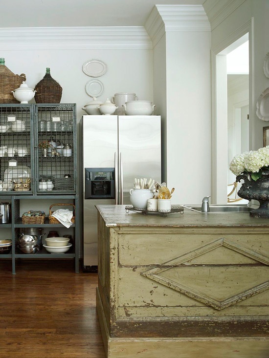 a large shabby chic wooden kitchen island has a different color and a vintage look and catches an eye