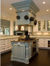 a unique pale blue two part kitchen island with a stained wooden countertop, an integrated cooker and some hanging pans on the upper part