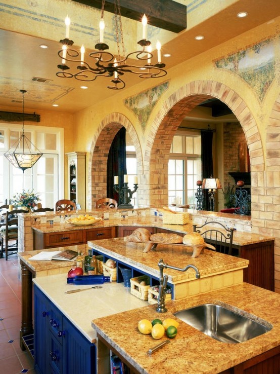 a creative kitchen island in rich stain with a navy sideboard integrated inside with stone countertops and an additional raised one