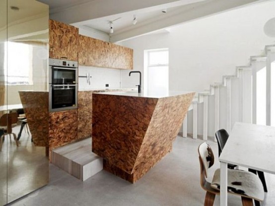 a sculptural geometric plywood kitchen island with hidden storage space stands out with its amazing shape and lines