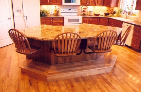 a geometric kitchen island with a stone countertop and chairs attached right to it to save some space