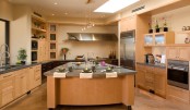 a large kitchen island of ocher painted plywood with a metal countertop, a sink and a meal space is rnough for every kind of kitchen work