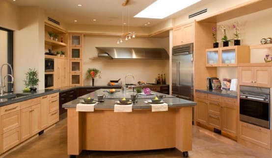 a large kitchen island of ocher painted plywood with a metal countertop, a sink and a meal space is rnough for every kind of kitchen work