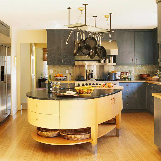 an asymmetrical kitchen island with a curved part, with lots of storage compartments, an open shelf and a dark stone tabletop