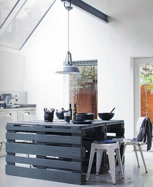 a slate grey pallet kitchen island with some eating space and cooking, too, stands out in a neutral kitchen