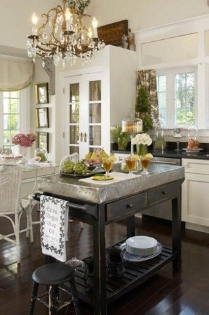 a dark stained kitchen island with a metal countertop features drawers and shelves for storage and feels very rustic and industrial