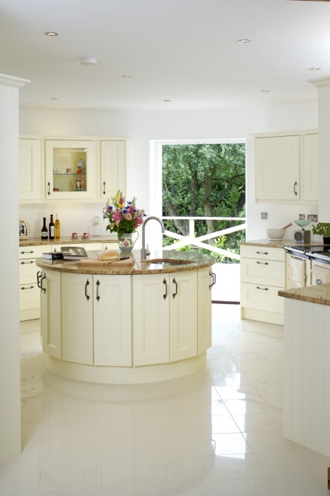 a round kitchen island that features cabinets on it whole square and a sink it a very creative piece with much storage space