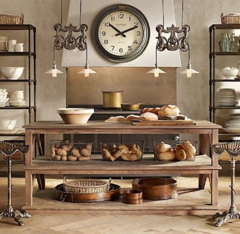 a simple rustic wooden kitchen island stands out in a kitchen with metal shelving units all over