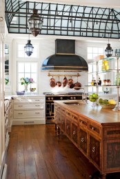 a rich stained oversized vintage kitchen island made of a sideboard features a lot of storage and a sink and adds elegance