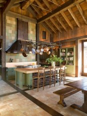 a green kitchen island with a butcherblock countertop hides some basket drawers inside and adds a rustic feel