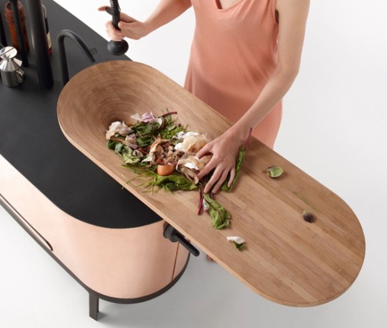 a curved sleek kitchen island with a black countertop and an additional cutting board on top is a gorgeous option for a minimalist space