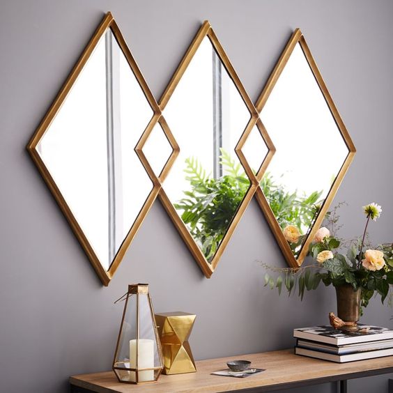 a rhomb-shaped triple mirror in brass frames is a lovely idea for a modern space, it brings a touch of geometry and shine to the space