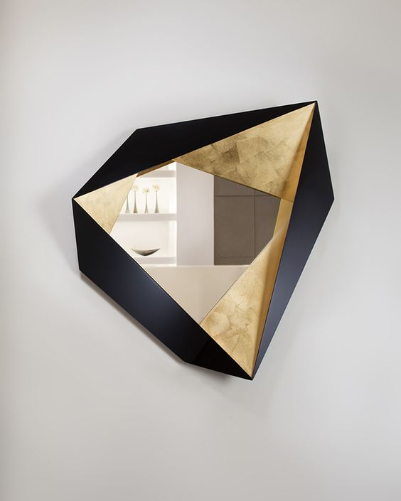 a fabulous faceted geometrically shaped mirror with gold and black timber parts is a fantastic artwork, not just a usual mirror