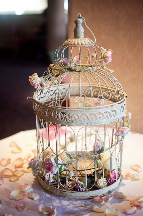 A bunch of real or faux roses would look amazing in a bird cage. It's a great idea for any kind of decorating.